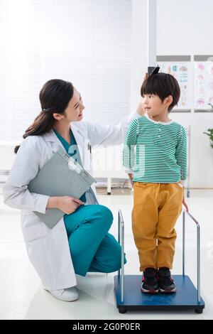 Il medico ha dato il ragazzo in altezza Foto Stock