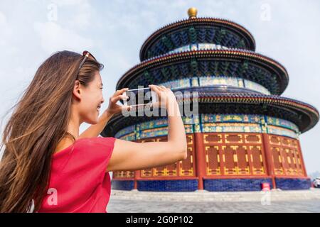 Asia viaggio turista donna cinese scattare foto con smartphone del tempio del cielo, una popolare attrazione turistica che è un edificio imperiale Foto Stock