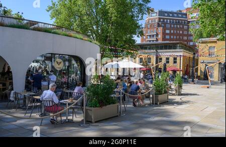 Londra, Inghilterra, giugno 2021. I londinesi godono della lunga ondata di caldo nel centro della città. Mangiare all'aperto in Duke of York Square sulla Kings Road. Foto Stock