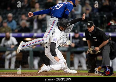 L'infedelder di Colorado Rockies Ryan McMahon (24) segna il gioco che ha vinto un campo selvaggio durante una partita di stagione regolare di MLB contro i Texas Rangers, Foto Stock