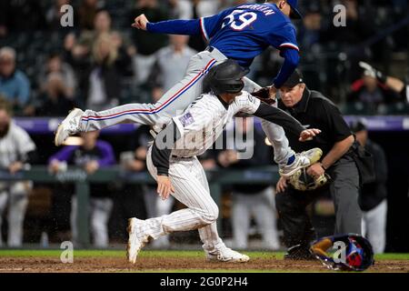 L'infedelder di Colorado Rockies Ryan McMahon (24) segna il gioco che ha vinto un campo selvaggio durante una partita di stagione regolare di MLB contro i Texas Rangers, Foto Stock