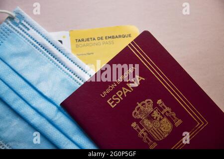 Maggio 2021. Spagna. Primo piano di un passaporto accanto a una maschera igienica e di una carta d'imbarco per un volo Foto Stock