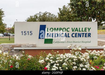Lompoc, CA, USA - 26 maggio 2021: Emblema bianco su blu su Chioseup del cartello all'ingresso del Lompoc Valley Medical Center. Auto in parcheggio e impianti aggiungere co Foto Stock