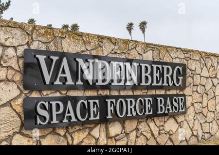 Lompoc, CA, USA - 26 maggio 2021: Primo piano del nome della base della forza spaziale Vandenberg sulla parete beige sotto il cielo grigio. Foto Stock