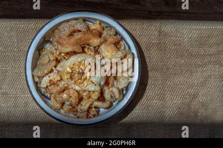 Crackling di maiale dal lardo o Crackle di maiale fritto in ciotola di ceramica. È un delizioso antipasto. Spazio di copia, fuoco selettivo. Foto Stock