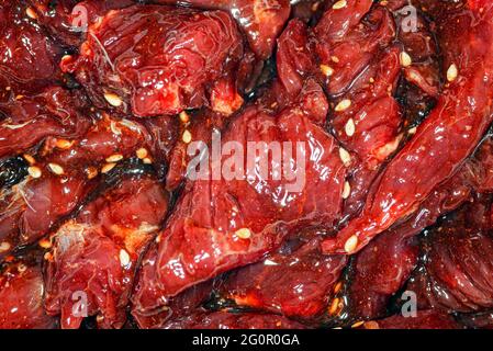 Fette di manzo marinate, luminose e succose, con spezie, olio e semi di sesamo Foto Stock