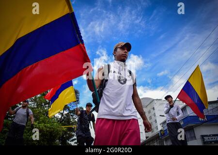 Passo, Narino, Colombia. 2 Giugno 2021. Demostrator batte la bandiera della Colombia nell'ambito dello sciopero nazionale di Pato, Narino, il 2 giugno; 2021 nel corso di una protesta anti-governativa contro le riforme fiscali e sanitarie del presidente Ivan Duque e i disordini e le violazioni causati in abusi di polizia di casi di potere che lasciano i leas 70 morti da quando le proteste sono scoppiate il 28 aprile. Credit: Camilo Erasso/LongVisual/ZUMA Wire/Alamy Live News Foto Stock