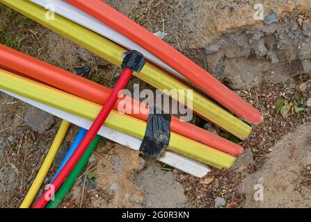 Trebnitz, Germania. 02 giugno 2021. Tubi vuoti colorati, nei quali saranno successivamente posati cavi in fibra ottica, sporgono dal suolo lungo una strada. Molte aziende locali stanno lanciando campagne di espansione per le connessioni Internet in fibra ottica. A questo scopo vengono posate nuove linee. Ciò che è già standard nelle città più grandi è ancora un sogno pipe per molti residenti rurali: Internet veloce. Sono stati spesi miliardi per spianare la strada all'era digitale anche nelle aree rurali. Ma in molti casi, i progressi sono lenti. Credit: Patrick Pleul/dpa-Zentralbild/ZB/dpa/Alamy Live News Foto Stock