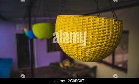 Molti vasi di plastica e contenitori per fiori sul balcone. Singolo vaso di plastica blu appeso con lamiera di ferro. Concetto di interni domestici. Foto Stock