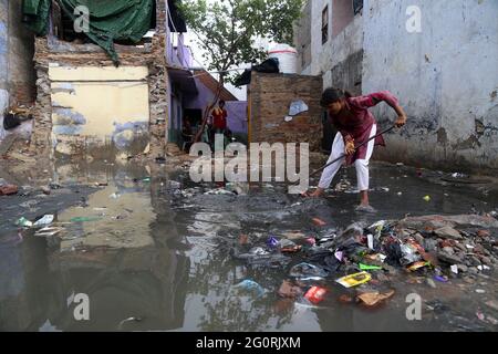 Beawar, Rajasthan, India, 2 giugno 2021: Una famiglia povera pulisce fuori l'acqua di pioggia dalla loro casa ad una zona di baraccopoli, dopo la pioggia pesante e la tempesta di tuono in Beawar. Delhi, Rajasthan, Uttarakhand su Alert come l'India del Nord braces per più pre-Monsone piogge e tempeste di tuoni dal 3 al 5 giugno. Credit: Sumit Saraswat/Alamy Live News Foto Stock