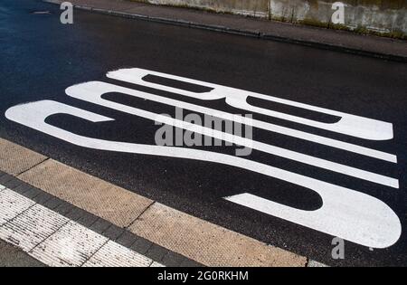 una fermata dell'autobus in un villaggio tedesco contrassegnato con test bianco sulla strada Foto Stock