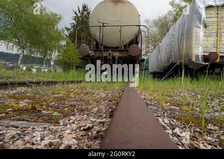 Treni merci scartati su binari ferroviari ciechi in zone industriali abbandonate. Foto Stock