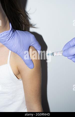 Primo piano medico che tiene la siringa e che usa il cotone prima di fare Foto Stock