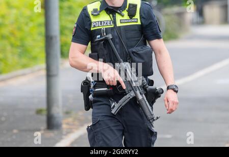 Celle, Germania. 03 giugno 2021. Un poliziotto pesantemente armato sta camminando alla corte di quartiere di celle. Nei locali della corte distrettuale un uomo ha sparato una donna e poi se stesso. Credit: Julian Stratenschulte/dpa/Alamy Live News Foto Stock