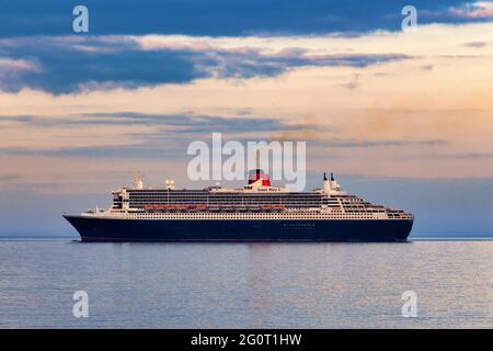 La magnifica nave da crociera Queen Mary 2 Ocean Liner si trova in un mare calmo mentre è ancorata al largo di Torbay in Devon, Regno Unito. Foto Stock