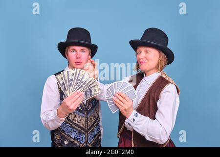 Attori uomo e donna con soldi dollari in mani su uno sfondo blu Foto Stock