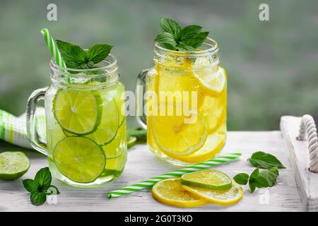 Fresca e rinfrescante limonata fatta in casa con menta, limone e lime in vasetti di muratore. Foto Stock