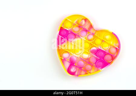 Giocattolo dai colori brillanti Pop it fidget su uno sfondo bianco con un posto per il testo Foto Stock