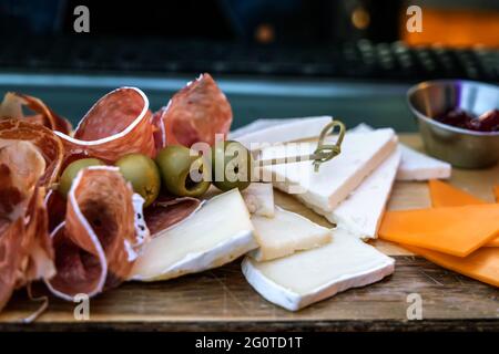 Salumi, formaggi e olive su tavola di salumi Foto Stock