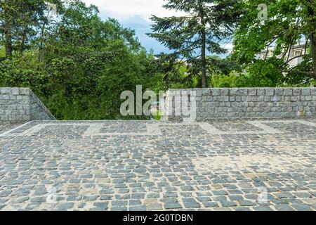 Recinzione e scala in pietra di granito. Un'area acciottolata con una recinzione in ciottoli di pietra. Piattaforma di osservazione nel parco cittadino Foto Stock