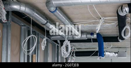 installazione del cablaggio elettrico e del sistema di condotti di ventilazione dell'aria nell'edificio Foto Stock