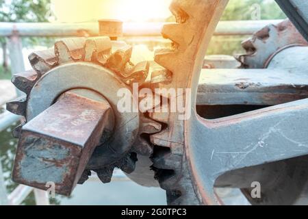 Primo piano su una base esterna in calcestruzzo vengono montati grandi ingranaggi del floodgate, utilizzati per controllare l'apertura e la chiusura del floodgate di una diga, rese Foto Stock