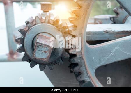 Primo piano su una base esterna in calcestruzzo vengono montati grandi ingranaggi del floodgate, utilizzati per controllare l'apertura e la chiusura del floodgate di una diga, rese Foto Stock