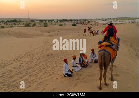 Deserto di Thar, Rajassthan, India - Ottobre 15th 2019 : una turista femminile che interagisce con la gente locale durante un giro in cammello sulle dune di sabbia del deserto di Thar. Foto Stock