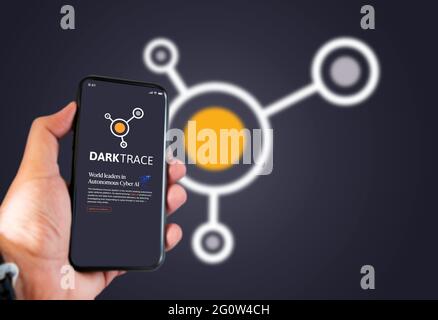 Cambridge, UK, maggio 2021: Una mano che tiene un telefono con il logo della società Darktrace sullo schermo. Darktrace è una società di intelligenza artificiale specializzata in cyber de Foto Stock