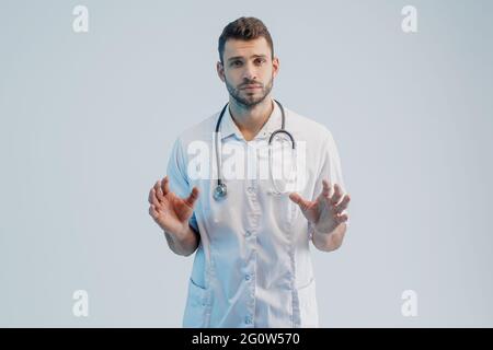 Serio giovane medico europeo di sesso maschile in studio Foto Stock