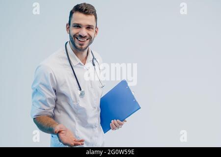 Felice giovane medico maschio europeo tenere appunti Foto Stock