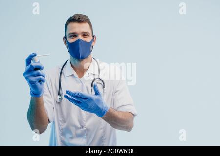Medico maschile europeo che mostra l'inalatore in studio Foto Stock