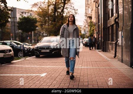 Donna premurosa che cammina per strada in città Foto Stock