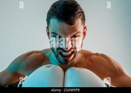 Giovane e arrabbiato pugile europeo in studio Foto Stock
