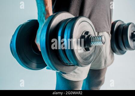 Primo piano di sportivo che tiene in mano i manubri Foto Stock