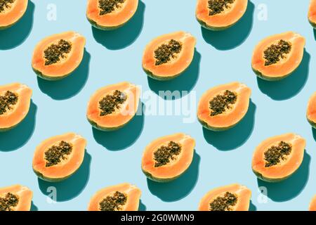 disegno creativo con frutta fresca di papaia con semi neri su sfondo blu. concetto di vacanza, estate e natura. vista dall'alto. Foto Stock