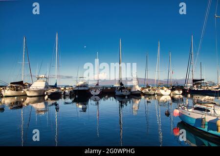 Lunare di mattina presto al porto di Lahaina con Lanai in lontananza. Foto Stock