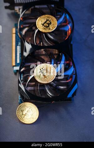 Moneta Bitcoin su una potente scheda grafica per il mining e guadagnare concetto di criptovaluta su uno sfondo scuro. Tecnologie della moneta futura. In alto Foto Stock