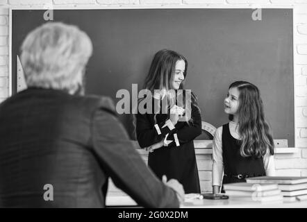 Studiare insieme. Dialogo e comunicazione. Vita scolastica quotidiana. Ritorno a scuola. Aiuto e supporto. Utilizzare in modo efficace le fonti primarie. Insegnante e bambini Foto Stock