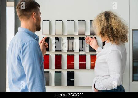Il venditore della concessionaria mostra al cliente i campioni del colore della carrozzeria Foto Stock