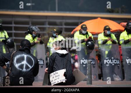 Bogotà, Colombia. 02 giugno 2021. Con la polizia alle sue spalle, un manifestante tiene un segno che recita 'la lotta di tutti per i valori di tutti'. In un nuovo giorno di protesta anti-governo a Bogotá, Colombia contro il governo del presidente Iván Duque e la brutalità della polizia il 2 giugno 2021 Credit: Long Visual Press/Alamy Live News Foto Stock