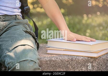 La mano del ragazzo è sul books.close up.schoolboy Foto Stock