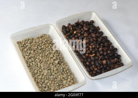 Chicchi di caffè in contenitori di plastica isolati su fondo bianco Foto Stock