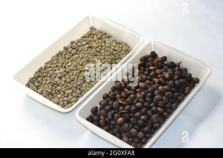 Chicchi di caffè in contenitori di plastica isolati su fondo bianco Foto Stock