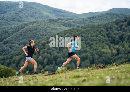 Gruppo di corridori che corrono su un sentiero lungo belle strade di montagna. Foto Stock