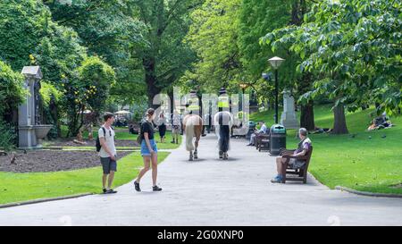 2 poliziotti in casa a cavallo attraverso un parco. Londra Foto Stock