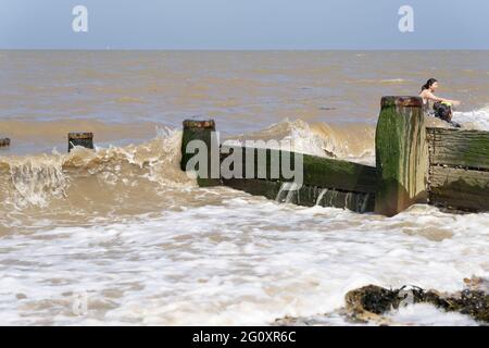 Gruppi di donne che giocano in onda di marea nel mare , Sheppey spiaggia, Kent, Inghilterra Foto Stock