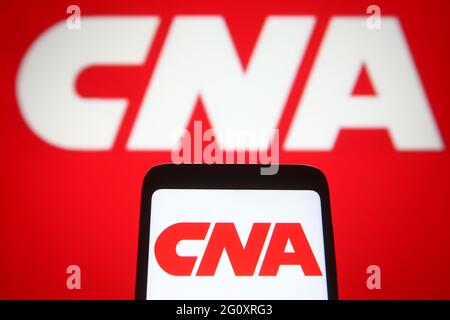 In questa illustrazione fotografica, un logo CNA Financial Corporation viene visualizzato su uno smartphone e sullo schermo del pc sullo sfondo. Foto Stock