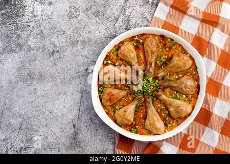 Bastoncini di pollo al forno e riso con in una teglia bianca su sfondo grigio scuro. Vista dall'alto, disposizione piatta Foto Stock