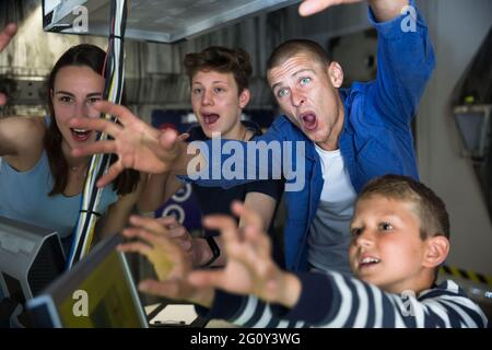 Una famiglia allegra che cerca qualcosa nella stanza di quest Foto Stock